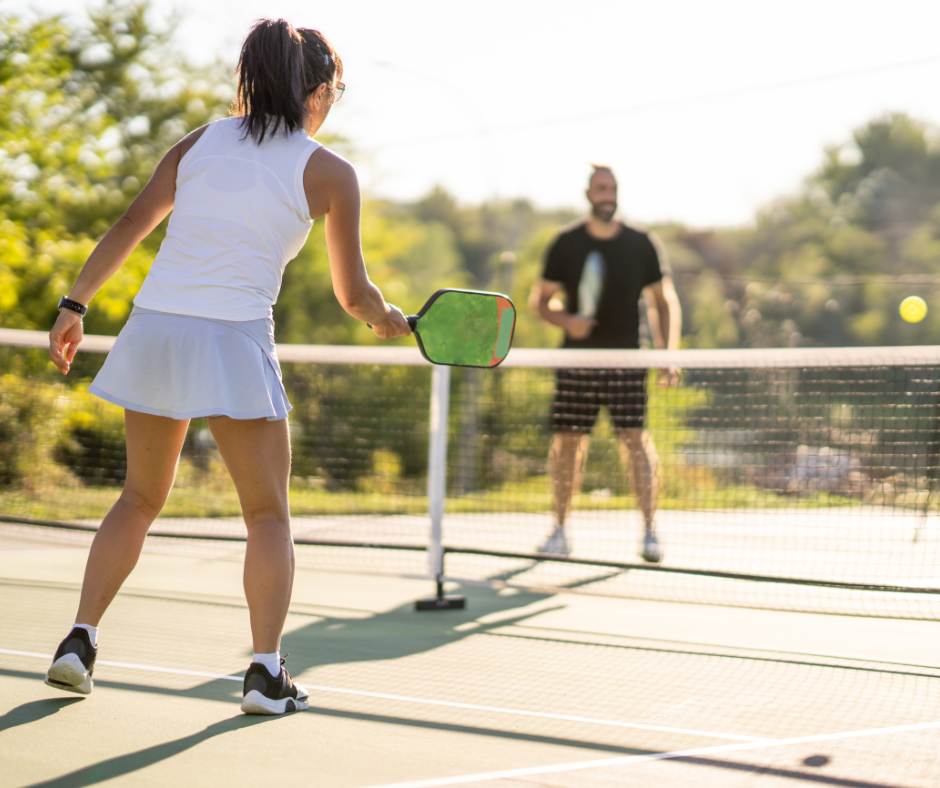 Woman and man playing pickleball - Pink Palm Travel resorts with pickleball courts